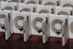 FIGURE 1. A nonlinear tunable metamaterial (for microwaves) is based on a series of printed-circuit boards with split-ring resonators and wires arranged to form a superlattice. FIGURE 1. A nonlinear tunable metamaterial (for microwaves) is based on a series of printed-circuit boards with split-ring resonators and wires arranged to form a superlattice.