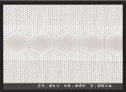 A scanning electron micrograph shows five coupled cavities situated in a photonic crystal; the entire structure of 40 cavities forms a laser. The brighter region straddling the hexagons defines the area where the pump current is injected, parallel to the microholes. A scanning electron micrograph shows five coupled cavities situated in a photonic crystal; the entire structure of 40 cavities forms a laser. The brighter region straddling the hexagons defines the area where the pump current is injected, parallel to the microholes.