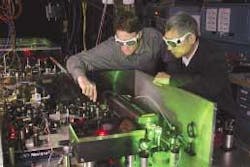 NIST physicist Scott Diddams, left, and Long-Sheng Ma of the International Bureau of Weights and Measures adjust a femtosecond laser oscillator that links optical frequencies to microwave time standards, providing a base for emerging optical clock technology.
