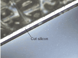FIGURE 2. A 70-&micro;m-thick wafer with an edge cut parallel to the edge of the wafer shows a thin ring of cut silicon about 50-&micro;m wide that appears white in the photo.