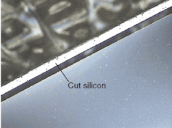 FIGURE 2. A 70-µm-thick wafer with an edge cut parallel to the edge of the wafer shows a thin ring of cut silicon about 50-µm wide that appears white in the photo. FIGURE 2. A 70-µm-thick wafer with an edge cut parallel to the edge of the wafer shows a thin ring of cut silicon about 50-µm wide that appears white in the photo.