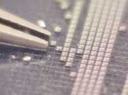 FIGURE 1. Picking up a 250-µm die with tweezers can be tricky. FIGURE 1. Picking up a 250-µm die with tweezers can be tricky.