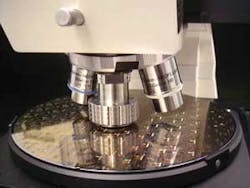 FIGURE 2. A prototype objective is based on a design similar to that shown in Fig. 1. The objective is in the center position on a standard six-position microscope turret between two large-diameter dark-field objectives. FIGURE 2. A prototype objective is based on a design similar to that shown in Fig. 1. The objective is in the center position on a standard six-position microscope turret between two large-diameter dark-field objectives.