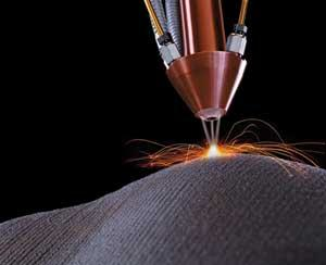 FIGURE 1. For laser cladding applications, powder blown through a nozzle or nozzles is sintered using heat from the central laser beam.