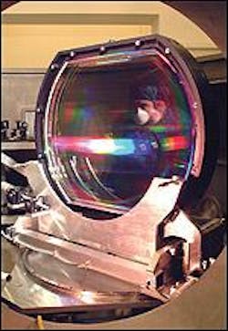 Trevor Winstone, quality-assurance manager of the Vulcan petawatt laser, inspects a 940-mm-diameter diffraction grating used for pulse compression.