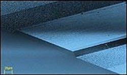 FIGURE 1. A scanning electron microscope reveals the front facet of a prototype terahertz laser and part of the ridge. The ridge was obtained by optical lithography and chemical wet etching of a plain wafer to a depth of 11 μm. Side contacts, seen as bright areas (upper left and lower right), collect the current. FIGURE 1. A scanning electron microscope reveals the front facet of a prototype terahertz laser and part of the ridge. The ridge was obtained by optical lithography and chemical wet etching of a plain wafer to a depth of 11 μm. Side contacts, seen as bright areas (upper left and lower right), collect the current.