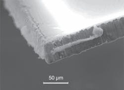 FIGURE 4. A SEM image shows increased debris and poor cut quality on the resultant die for “double pulse” irradiation at 4 m/s scan speed. FIGURE 4. A SEM image shows increased debris and poor cut quality on the resultant die for “double pulse” irradiation at 4 m/s scan speed.