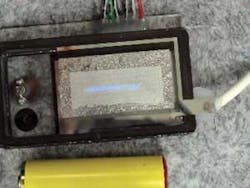 A prototype far-UV emitter combines a cold-cathode electron emitter with an hBN FED array 17 × 1.6 mm in size (bluish-white line). Note the AA battery placed next to it as a size comparison. For this particular device, impure hBN powder was used for the fluorescent screen because it emits blue light that can be captured with a commercially available digital camera. A prototype far-UV emitter combines a cold-cathode electron emitter with an hBN FED array 17 × 1.6 mm in size (bluish-white line). Note the AA battery placed next to it as a size comparison. For this particular device, impure hBN powder was used for the fluorescent screen because it emits blue light that can be captured with a commercially available digital camera.