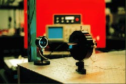 Scanning confocal etalon is used for routine analysis of laser spectra in Jeff Dixon’s laboratory. Output of an argon-ion laser is sampled by an angled flat mounted on the front of the confocal cavity mount (lower right). Electronic drive unit for the spectrum analyzer is positioned on top of an oscilloscope (background). Proper adjustment of the electronic drive unit and oscilloscope permit the longitudinal-mode spectrum of the argon-ion laser to be displayed. Scanning confocal etalon is used for routine analysis of laser spectra in Jeff Dixon’s laboratory. Output of an argon-ion laser is sampled by an angled flat mounted on the front of the confocal cavity mount (lower right). Electronic drive unit for the spectrum analyzer is positioned on top of an oscilloscope (background). Proper adjustment of the electronic drive unit and oscilloscope permit the longitudinal-mode spectrum of the argon-ion laser to be displayed.