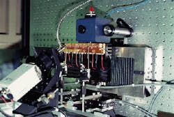 FIGURE 2. In laser diode bar-test station, two probes are lowered to power the diodes; output from the first goes to an integrating sphere (in blue box) and output from the second goes to a beam profiler (not shown). FIGURE 2. In laser diode bar-test station, two probes are lowered to power the diodes; output from the first goes to an integrating sphere (in blue box) and output from the second goes to a beam profiler (not shown).