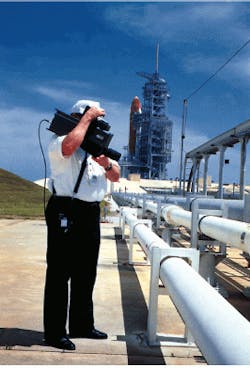 FIGURE 1. Kennedy Space Center engineer uses a portable thermal imaging camera to monitor liquid-oxygen lines for leaks during propellant loading of the Space Shuttle Columbia, on the launch pad in the background. FIGURE 1. Kennedy Space Center engineer uses a portable thermal imaging camera to monitor liquid-oxygen lines for leaks during propellant loading of the Space Shuttle Columbia, on the launch pad in the background.