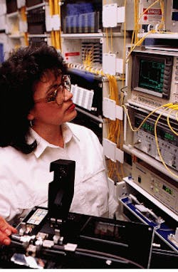 Technician tests a connector in the controlled environment of the laboratory to ensure proper performance. Technician tests a connector in the controlled environment of the laboratory to ensure proper performance.
