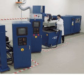 FIGURE 2. Because laser gas suppliers often provide essentially the same products, many are concentrating on added services to retain and expand their customer bases. Here a gas-company scientist conducts laser-gas research with a high-power industrial laser.