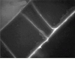 Scanning electron micrograph shows cross section (top) and top view of typical vias drilled in 50-micron-thick polyimide. Optimized parameters result in a drilling rate of 20 ms per hole using 266-nm output, while at 355 nm the rate is reduced to 5 ms per hole, a fourfold improvement. Scanning electron micrograph shows cross section (top) and top view of typical vias drilled in 50-micron-thick polyimide. Optimized parameters result in a drilling rate of 20 ms per hole using 266-nm output, while at 355 nm the rate is reduced to 5 ms per hole, a fourfold improvement.
