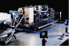 FIGURE 2. Automated electro-optic printed-circuit-board inspection machine uses three polygon-mirror laser scan-head assemblies to insure against release of defective components.