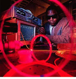 Daryl Inniss adjusts controls on Lucent Technologies fiber laser. Research suggests even higher diffraction-limited CW output power can be produced in the 1050-1700-nm wavelength region.