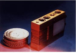 FIGURE 1. High-power diode laser module made from 10 diode bars of improved quality on a heat sink delivers CW optical power of 300 W. The stack of DM5 coins represents the cost per watt ($14.25). FIGURE 1. High-power diode laser module made from 10 diode bars of improved quality on a heat sink delivers CW optical power of 300 W. The stack of DM5 coins represents the cost per watt ($14.25).