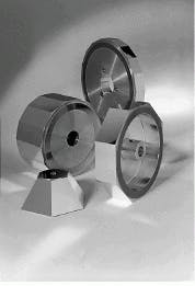FIGURE 3. Three common diamond-machined polygonal mirror assemblies are the regular (back and back left), irregular (front right), and pyramid (front left). Irregular polygons, though the most versatile, are the most expensive to manufacture because they can seldom be stacked or grouped together during processing. FIGURE 3. Three common diamond-machined polygonal mirror assemblies are the regular (back and back left), irregular (front right), and pyramid (front left). Irregular polygons, though the most versatile, are the most expensive to manufacture because they can seldom be stacked or grouped together during processing.