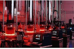 FIGURE 4. Fifteen-foot-long thin-walled tubes of multicrystalline silicon can be pulled from molten silicon using the edge-defined film-fed growth method. FIGURE 4. Fifteen-foot-long thin-walled tubes of multicrystalline silicon can be pulled from molten silicon using the edge-defined film-fed growth method.