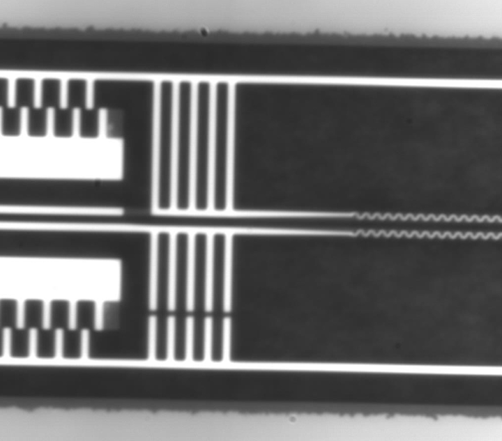 A high-magnification microscope still video image shows the high-precision micro-electromechanical systems (MEMS) used to control the distance between two beams at different temperatures. The whole frame dimension is comparable to the diameter of a strand of human hair. (Image credit: Columbia University)