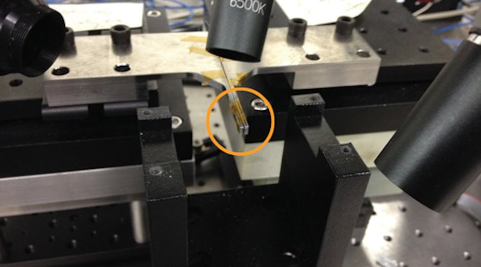 FIGURE 1. Optical fibers ride on finger probes (circled), enabling alignment of multiple fibers with accuracies better than 100 nm.