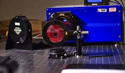 Example 2. Etched into a silicon wafer, the photon sieve shown below is a lab test device developed at NASA’s Goddard Space Flight Center (Greenbelt, MD); it is a miniature prototype of a future 1-m-diameter photon sieve that could one day be used in space to image the Sun at UV wavelengths. While this photon sieve brings red laser light to a pinpoint focus on its optical axis, it produces exotic diffraction patterns when viewed from the side, as seen here. Example 2. Etched into a silicon wafer, the photon sieve shown below is a lab test device developed at NASA’s Goddard Space Flight Center (Greenbelt, MD); it is a miniature prototype of a future 1-m-diameter photon sieve that could one day be used in space to image the Sun at UV wavelengths. While this photon sieve brings red laser light to a pinpoint focus on its optical axis, it produces exotic diffraction patterns when viewed from the side, as seen here.