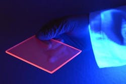 Luminescence from silicon quantum dots excited by UV light highlights the edge of the LSC, which concentrates the visible light given off by the quantum dots.