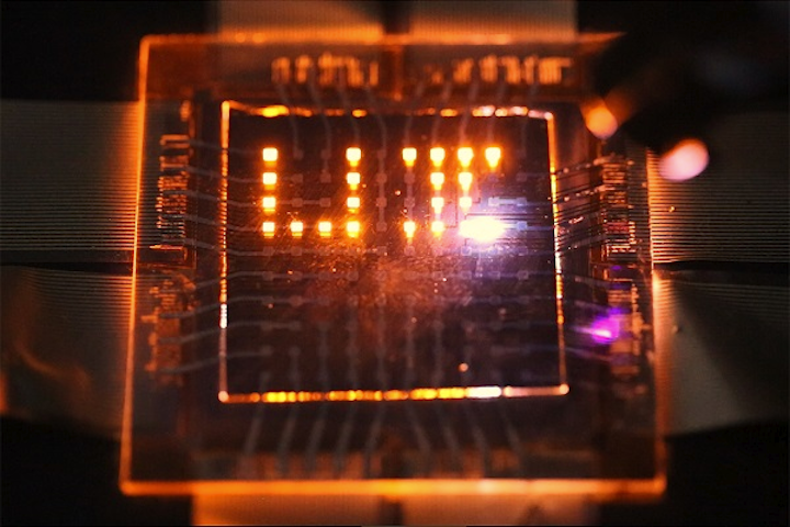 A laser stylus writes on a small array of multifunction pixels made by dual-function LEDs that can both emit and respond to light. (Image credit: Moonsub Shim/University of Illinois Urbana-Champaign)
