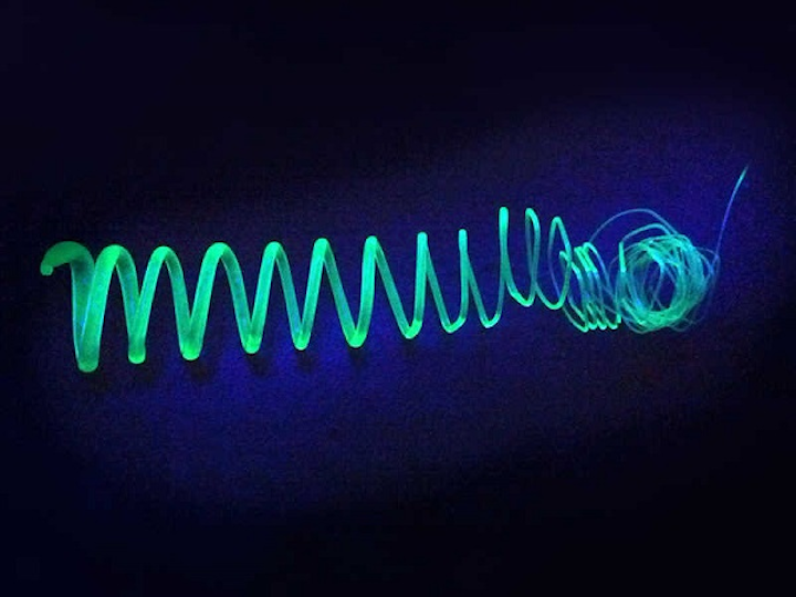 An extruded spiral made of polymer-coated silicon nanosheets glows in UV light. (Image credit: Tobias Helbich / TUM)
