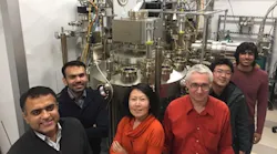 Members of the Cornell group stand in front of a molecular beam epitaxy system.
