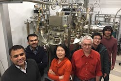 Members of the Cornell group stand in front of a molecular beam epitaxy system. Members of the Cornell group stand in front of a molecular beam epitaxy system.