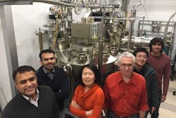 Members of the Cornell group stand in front of a molecular beam epitaxy system.
