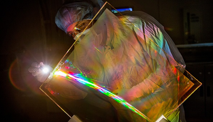 Marcus Monticelli inspects the anti-reflective coating on a National Ignition Facility grating debris shield. The coating restores lost NIF energy and eliminates a source of optics damage. (Image credit: Jason Laurea/LLNL)