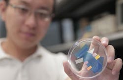 Researcher Zhenyang Xia holds a dish containing germanium-film photodetector samples. The sample colors vary depending on what wavelength they are tuned to absorb.