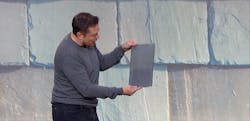 Tesla CEO Elon Musk is seen holding a tile amid an image of one style of the Tesla solar roof; note the solar panel just under the semi-transparent tile surface. Tesla CEO Elon Musk is seen holding a tile amid an image of one style of the Tesla solar roof; note the solar panel just under the semi-transparent tile surface.