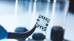 A new flexible graphene solar cell developed at MIT is seen in the transparent region at the center of this sample. Around its edges are metal contacts on which probes can be attached during tests of device performance.