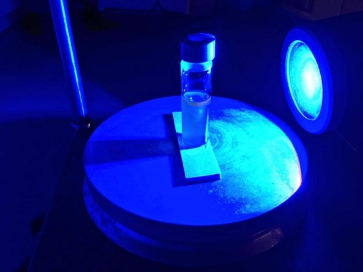 A blue LED shines on a vial containing heavy water, a pharmaceutical compound, and a light-activated catalyst. Princeton chemistry professor David MacMillan and colleagues have developed a new photocatalytic approach to hydrogen isotope exchange (HIE) that turns a multi-month process into a one-day step, speeding the arrival of new drugs to the marketplace. (Image credit: Princeton University)