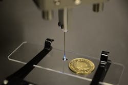 An optical fiber housed inside this needle delivers light for 3D printing of microstructures. The light selectively hardens volumes inside the droplet of photopolymer on the glass slide. The new system could one day allow 3D printing inside the body.