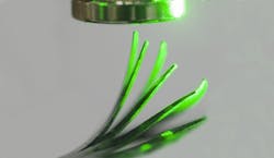 Incident light (from right) causes an elastomer film to deflect in a magnetic field. Incident light (from right) causes an elastomer film to deflect in a magnetic field.