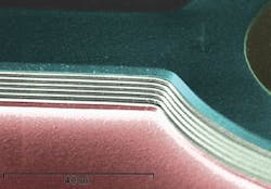 A colorized, zoomed-in scanning-electron micrograph (SEM) image shows an air-gapped distributed Bragg reflector (DBR) sandwiched by two channels. A colorized, zoomed-in scanning-electron micrograph (SEM) image shows an air-gapped distributed Bragg reflector (DBR) sandwiched by two channels.