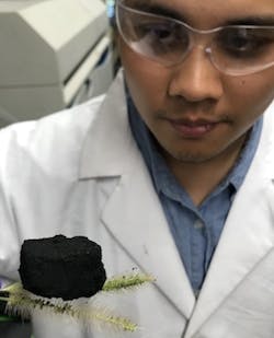 IMAGE:Rice graduate student Duy Xuan Luong suspends a three-dimensional block of laser-induced graphene atop two willows. The lab uses an industrial laser to transform inexpensive polyimide plastic into graphene foam at room temperature, and then binds the sheets to produce lightweight, conductive 3D graphene.