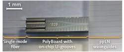 FIGURE 4. The coupling interface is shown for a waveguide-inscribed ppLN crystal from Universit&auml;t Paderborn and a PolyBoard interposer with U-groove-integrated single-mode fibers.
