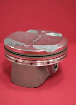 A car engine piston off the production line of a large auto manufacturer is shown; the piston has been treated with a femtosecond laser for enhanced engine performance.