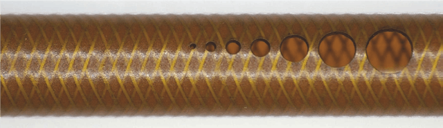 FIGURE 3. An ultrashort-pulse (USP) fiber laser machines holes in a catheter tube constructed from a metal/polymer layered material. (Courtesy of Blueacre Technology)