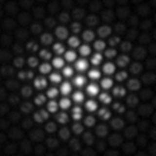 FIGURE 2. A defocused fluorescent point source is imaged through an optical fiber bundle. Different modal patterns encode spatially varying angular ray distributions. The central cores carry mostly normally incident light that couples to the fundamental modes of the cores. Higher-angle-of-incidence light that arrives at the periphery of the defocused spot is transmitted mainly by higher-order modes, visible as lobed structures or rings.
