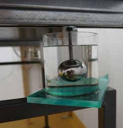 FIGURE 2. In addition to the steel-spring ceiling suspension, damping is provided by steel spheres immersed in highly viscous silicone oil. FIGURE 2. In addition to the steel-spring ceiling suspension, damping is provided by steel spheres immersed in highly viscous silicone oil.