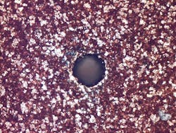 FIGURE 2. A clean 40 µm via drilled in PCB material with a CO laser is shown. FIGURE 2. A clean 40 µm via drilled in PCB material with a CO laser is shown.