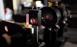 FIGURE 2. Phosphate laser glass is shown in an end-pumped laser cavity undergoing performance testing. FIGURE 2. Phosphate laser glass is shown in an end-pumped laser cavity undergoing performance testing.