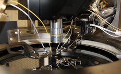 FIGURE 3. Cascade Microtech's CM300xi photonics-enabled engineering wafer probe station integrates PI's Fast Multichannel Photonics Alignment (FMPA) systems for high throughput, wafer-safe, nanoprecision optical probing of on-wafer silicon photonics devices. Both the six-axis hexapod positioner (top left) and the piezo XYZ scanner (black cube mounted on the hexapod) are based on parallel-kinematics for improved dynamics and precision. FIGURE 3. Cascade Microtech's CM300xi photonics-enabled engineering wafer probe station integrates PI's Fast Multichannel Photonics Alignment (FMPA) systems for high throughput, wafer-safe, nanoprecision optical probing of on-wafer silicon photonics devices. Both the six-axis hexapod positioner (top left) and the piezo XYZ scanner (black cube mounted on the hexapod) are based on parallel-kinematics for improved dynamics and precision.