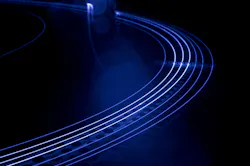 A main amplifier fiber similar to the fiber used in the paper, but a little longer, glows during operation (the blue color is due to a camera filter; unfiltered, the fiber appears green while operating).